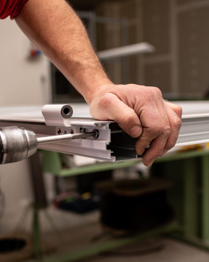 A male with a red shirt making a window with industrial tools