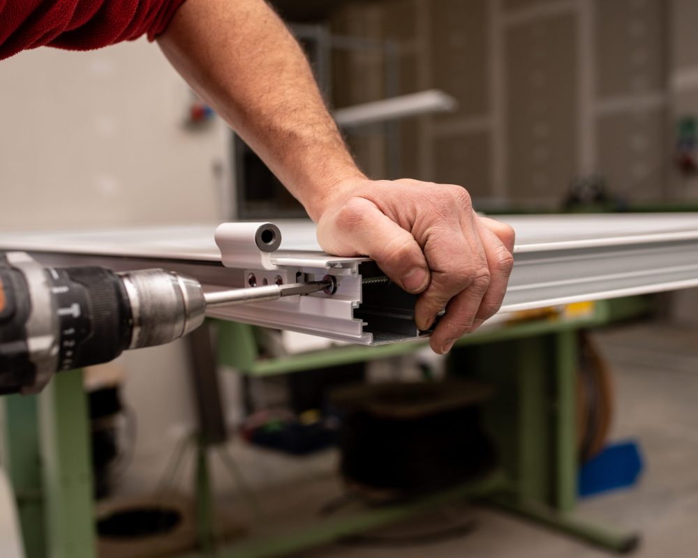 A male with a red shirt making a window with industrial tools